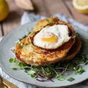Angled view of savory French toast with a fried egg on top over greens.