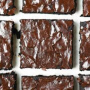 A close up of brownies on a white surface.