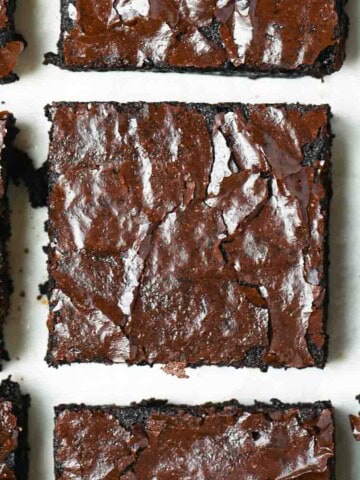 A close up of brownies on a white surface.
