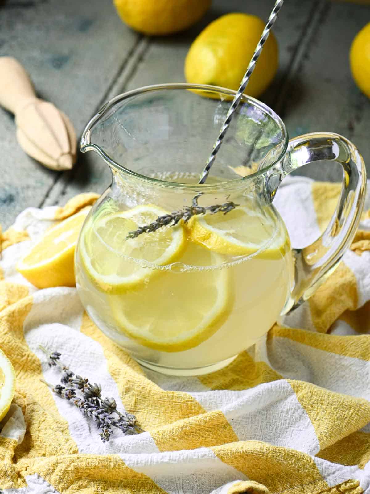 Lemonade in a pitcher with a straw.