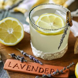 Lavender lemonade in a glass with a wooden sign.