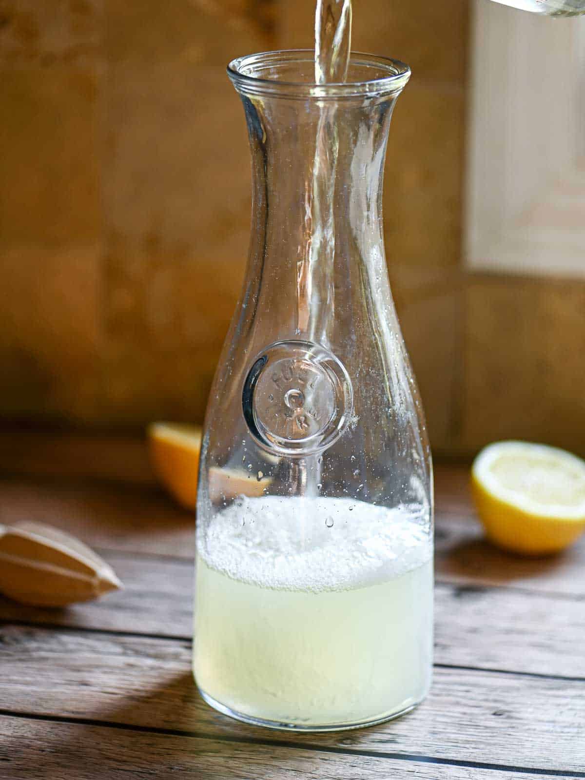 Water and lemon juice in a tall glass pitcher.