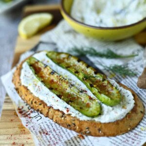 Grilled cucumber toast on a wood board.