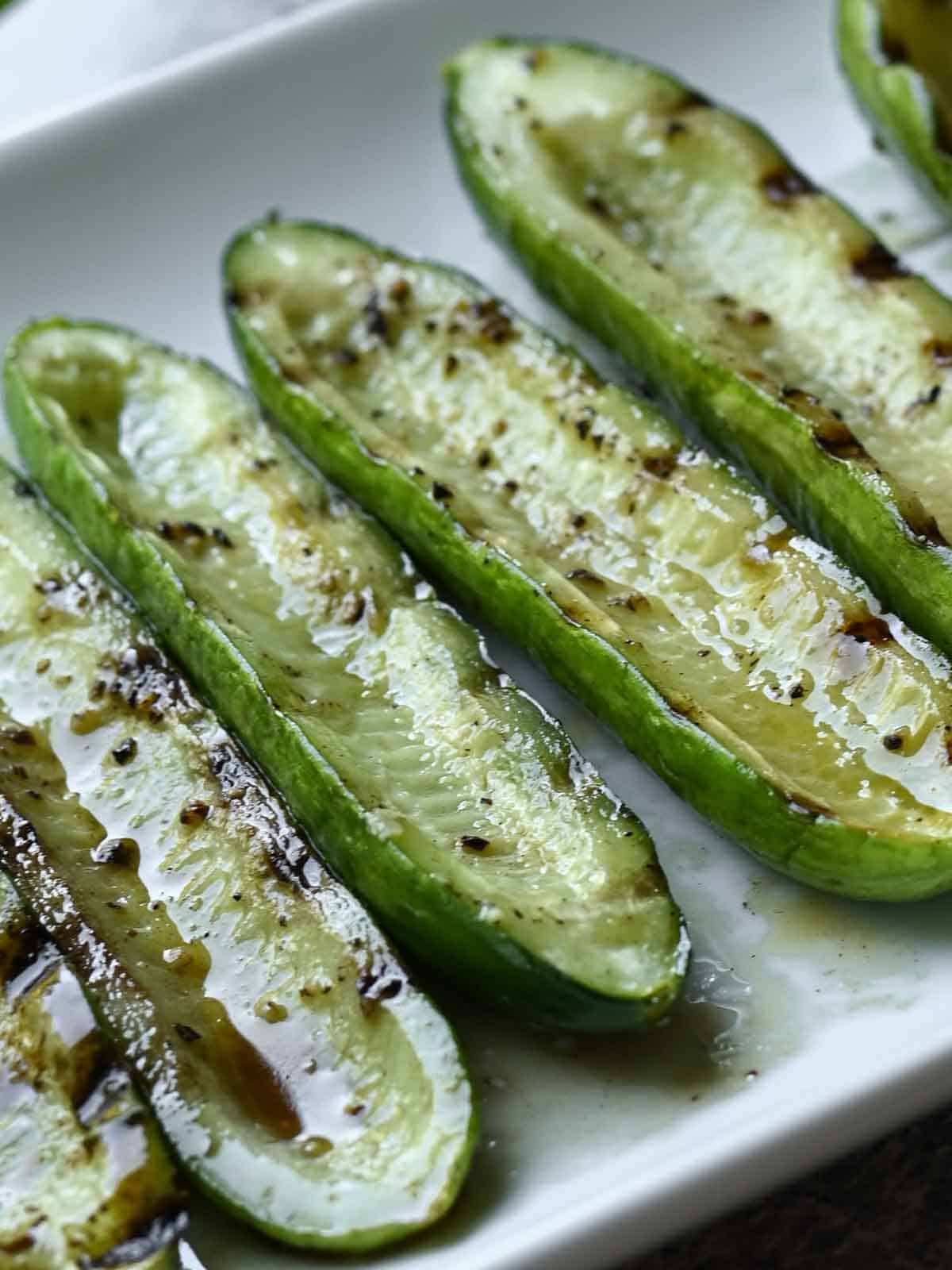 Close-up of grilled cucumber in a white plate.