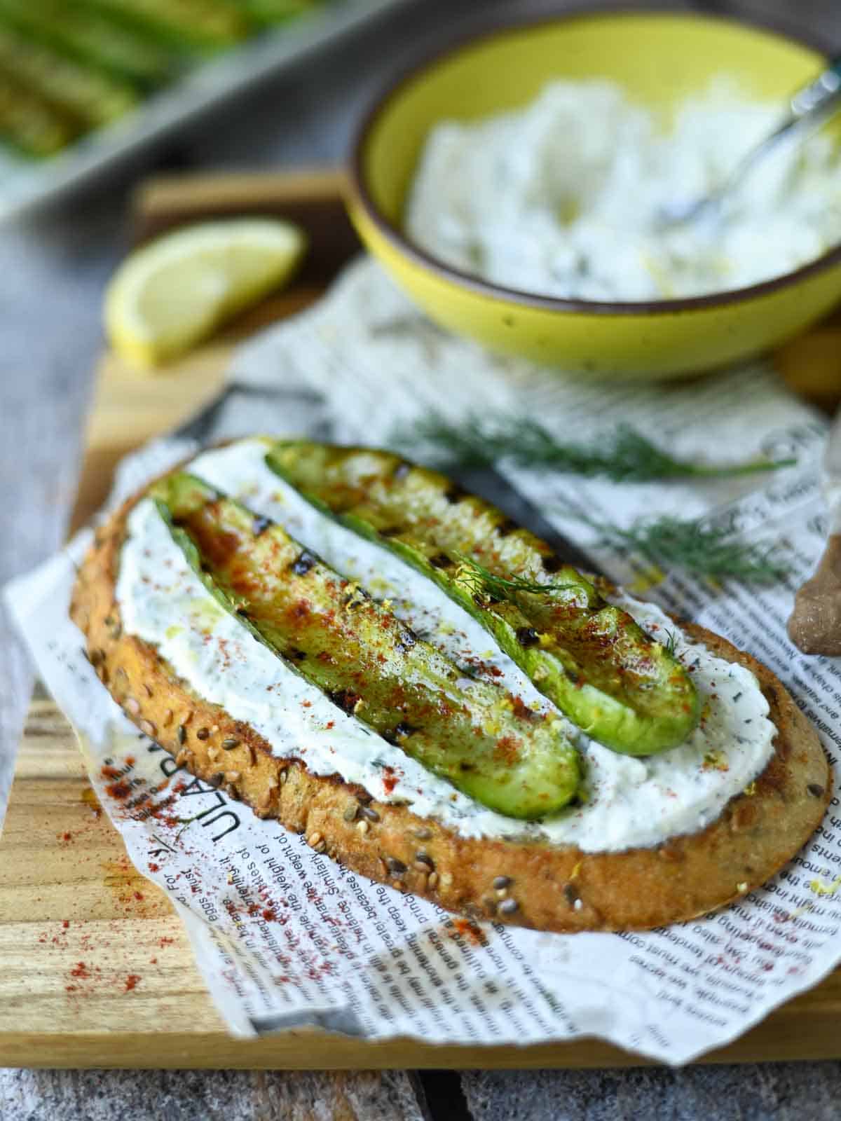 Grilled cucumber toast on a wood board.