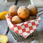 Ricotta doughnuts in a fry basket with a red checkered liner.