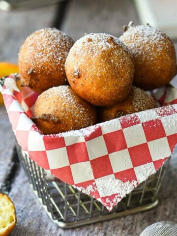 Ricotta doughnuts in a fry basket with a red checkered liner.