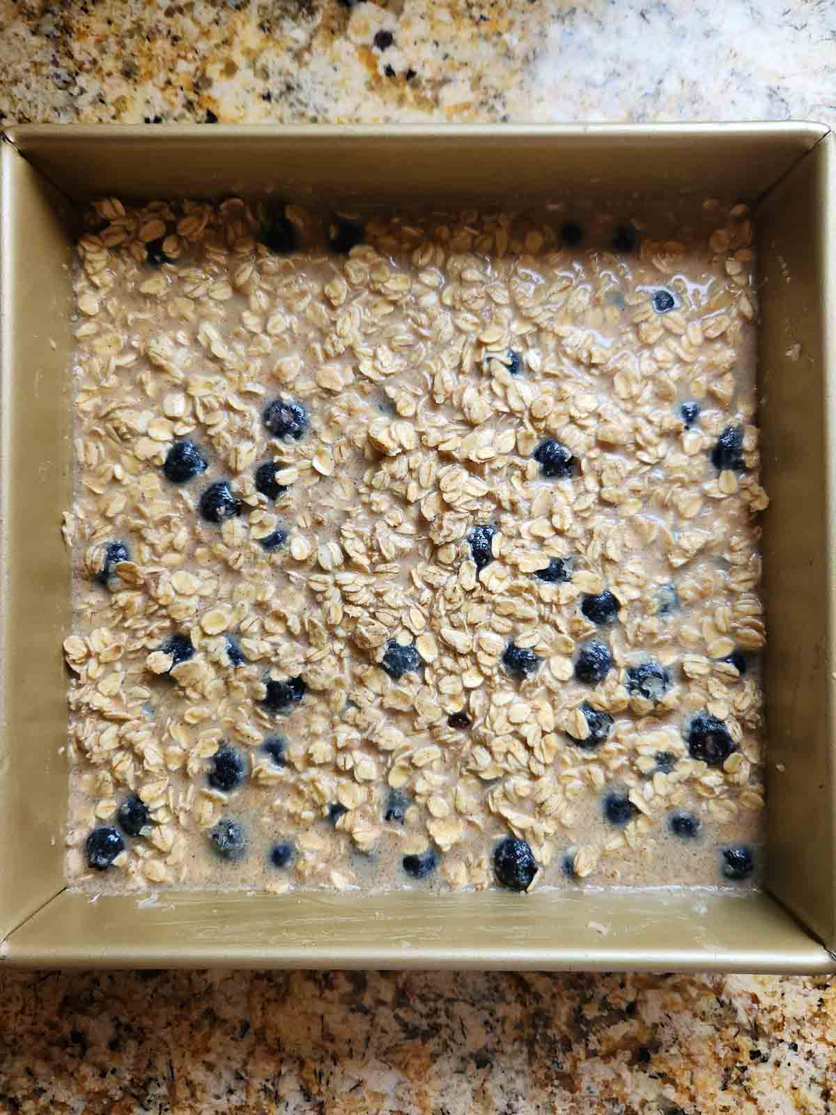 Overhead of baked oatmeal batter in a square baking pan.