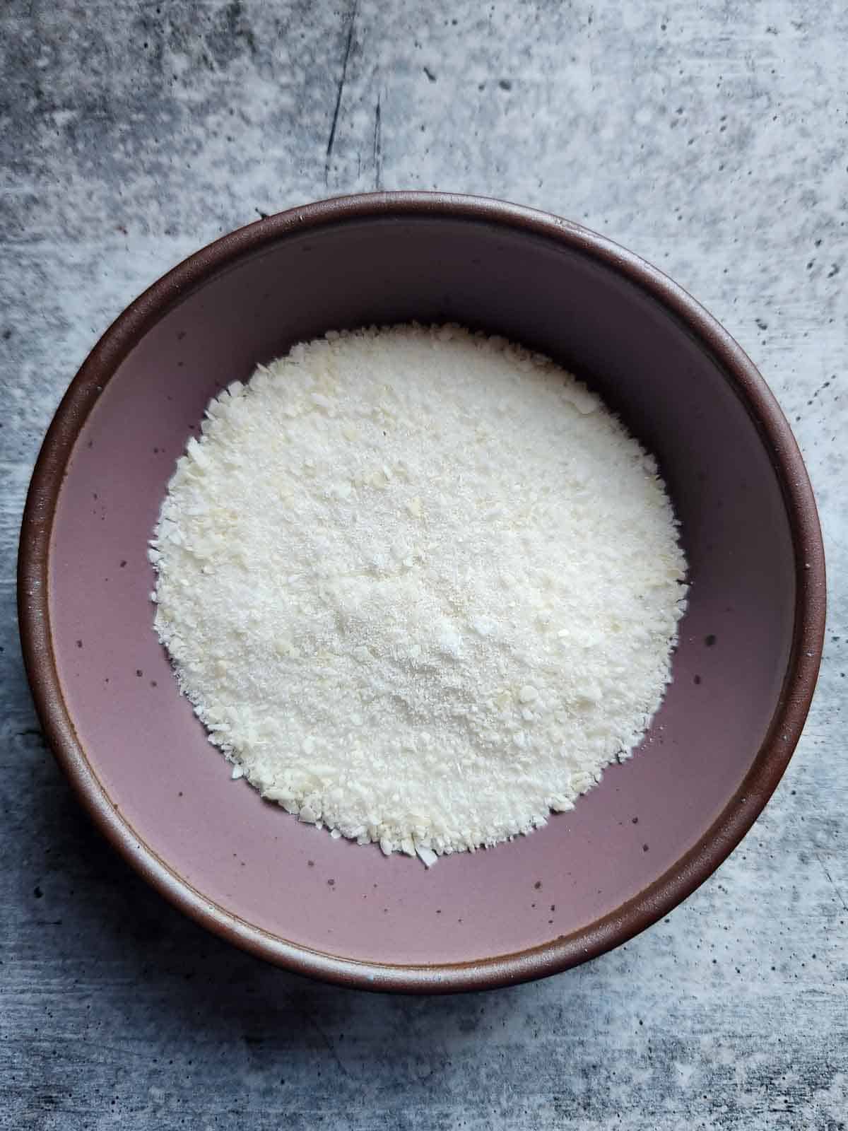 Coconut sugar in a purple bowl.
