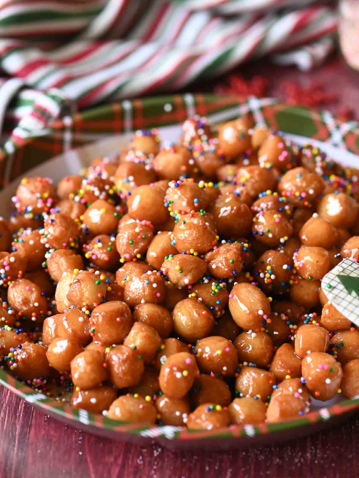A tray of Italian honey balls with on a Christmas plate.