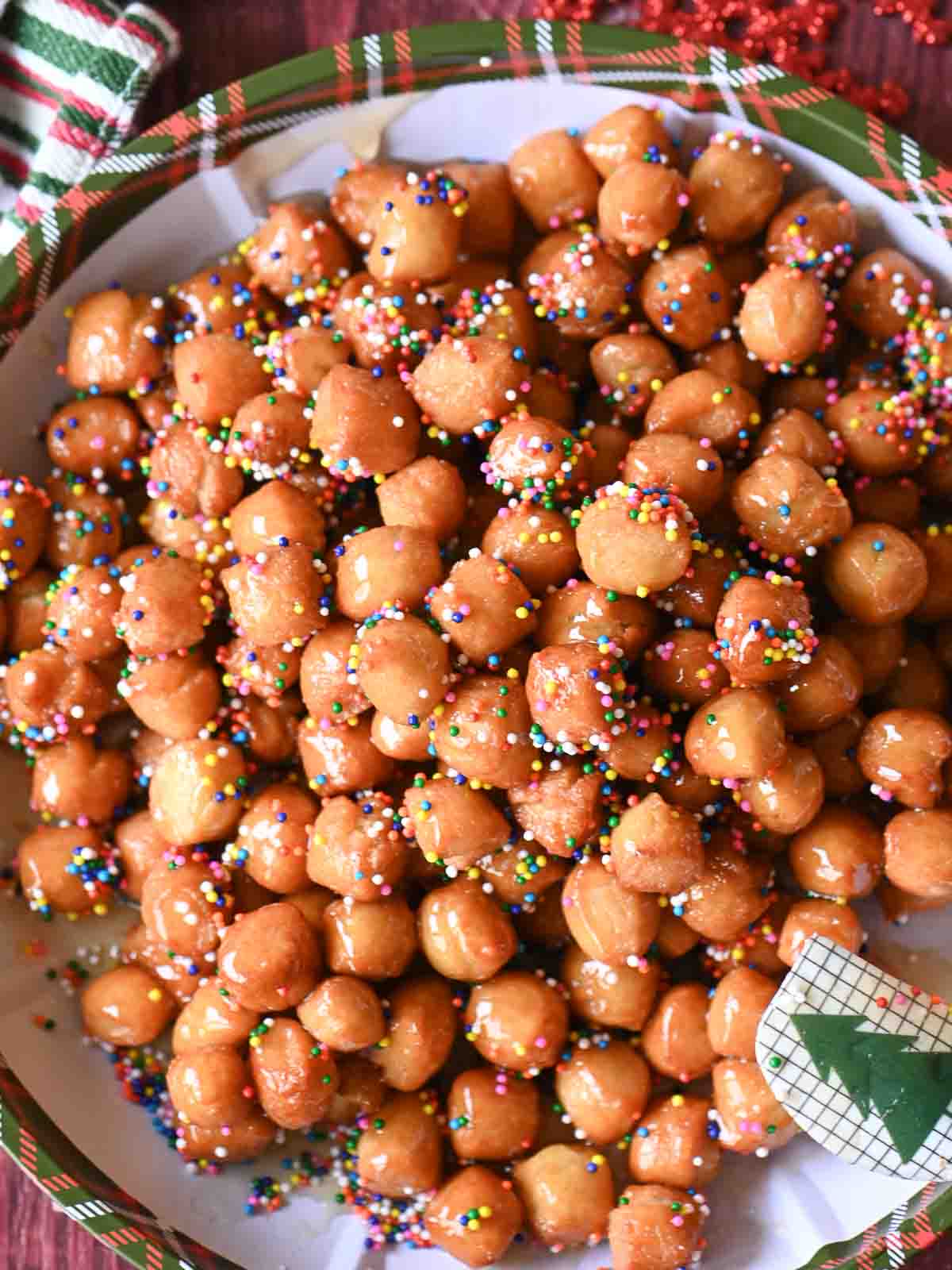 Overhead of struffoli on a Christmas plate.