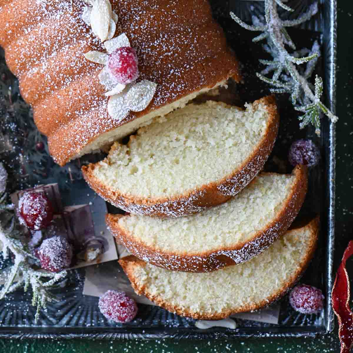 Overhead of almond cake sliced showing 3 pieces on a tray.