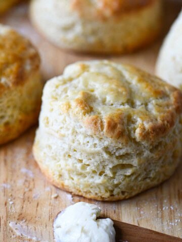 Close up of a golden top biscuit on a cutting board.