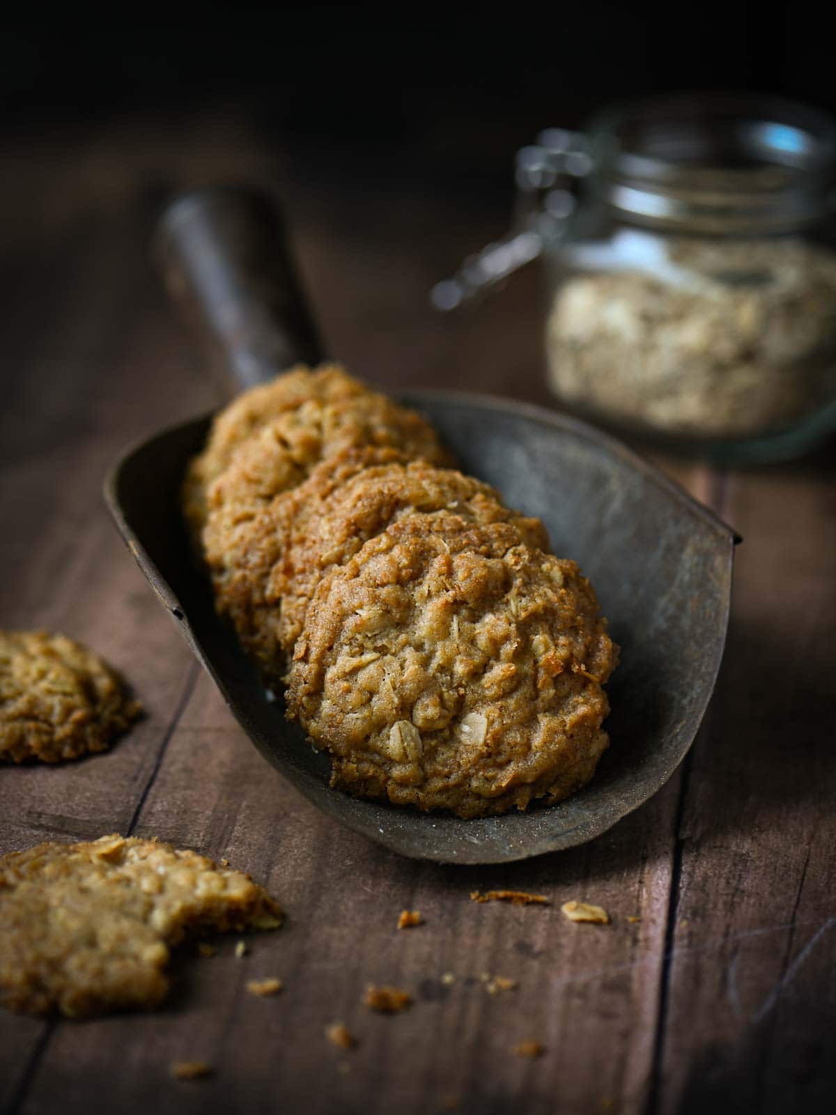 Oatmeal cookies in a large metal scoop.