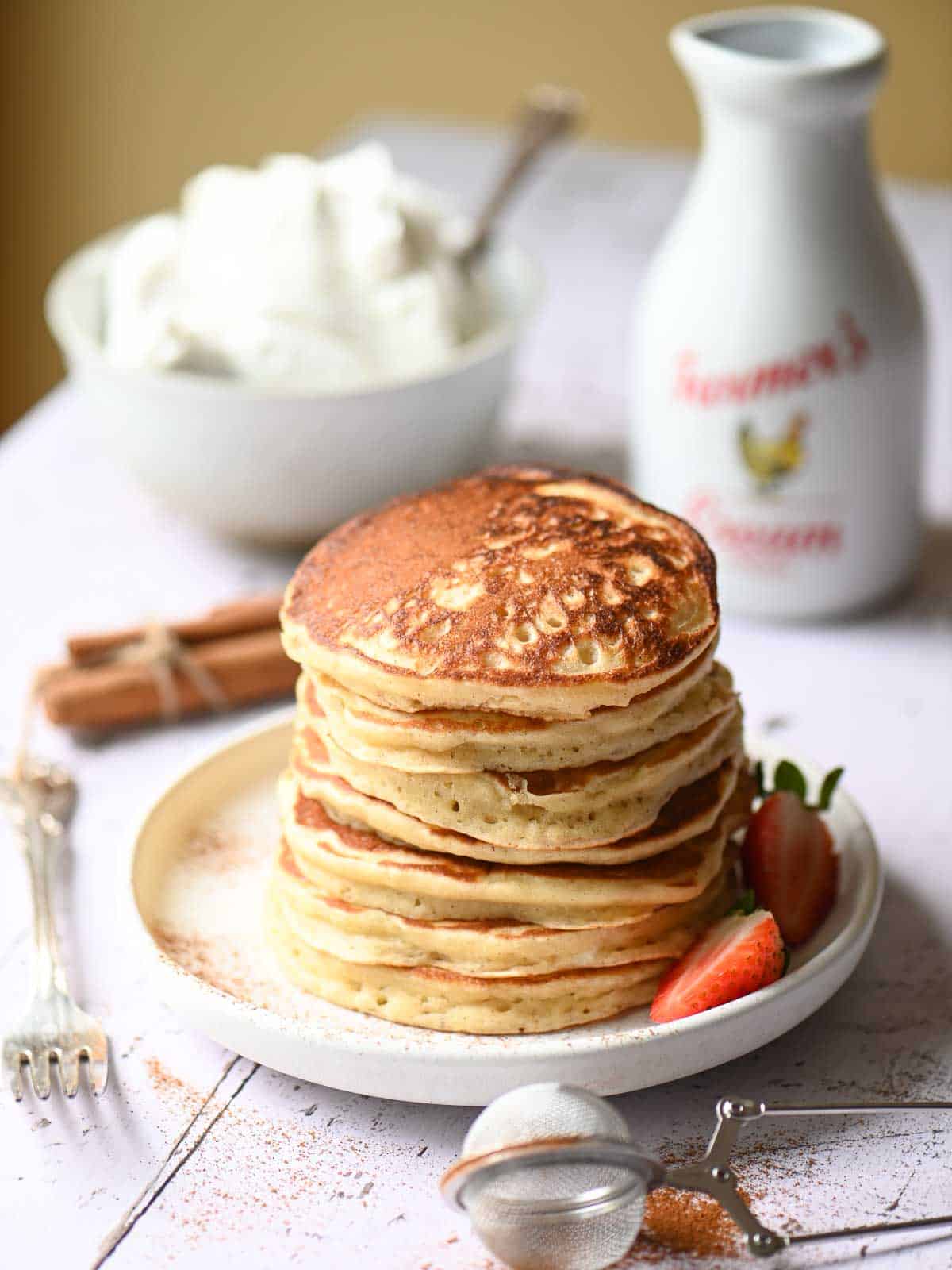 A stack of cinnamon pancakes on a white plate.