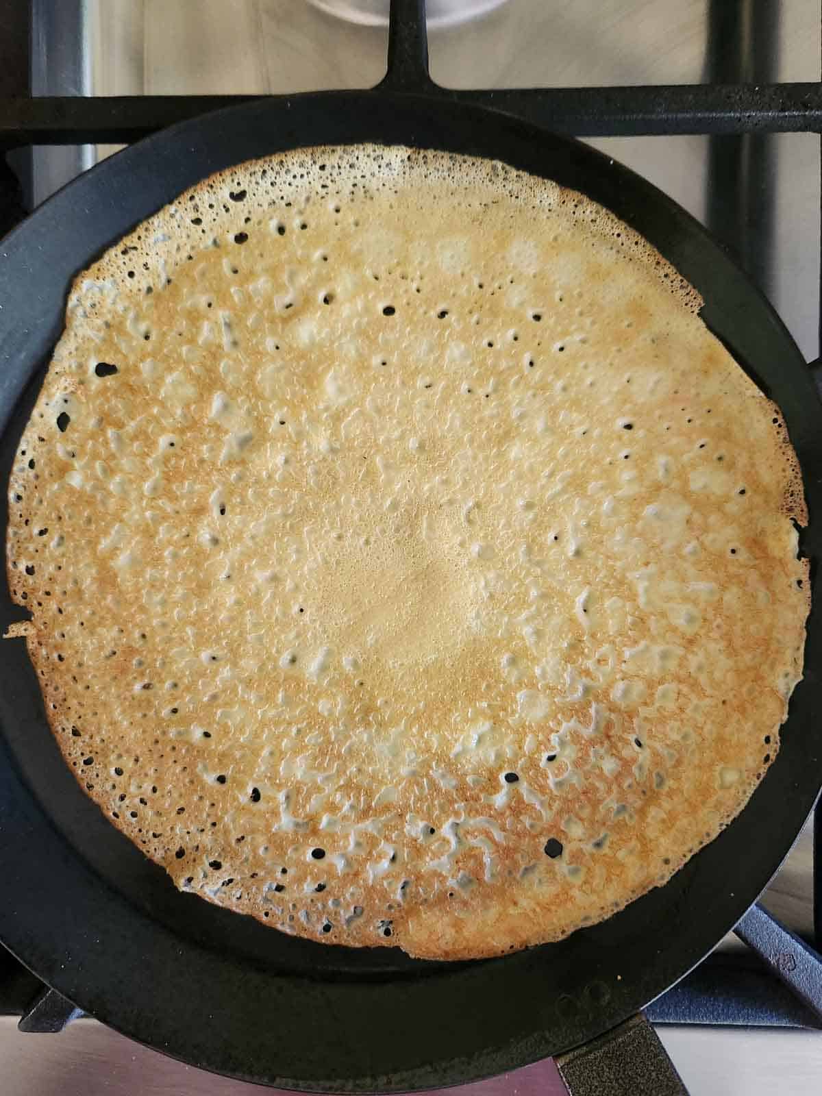 Overhead of a cooked crepe in a pan.