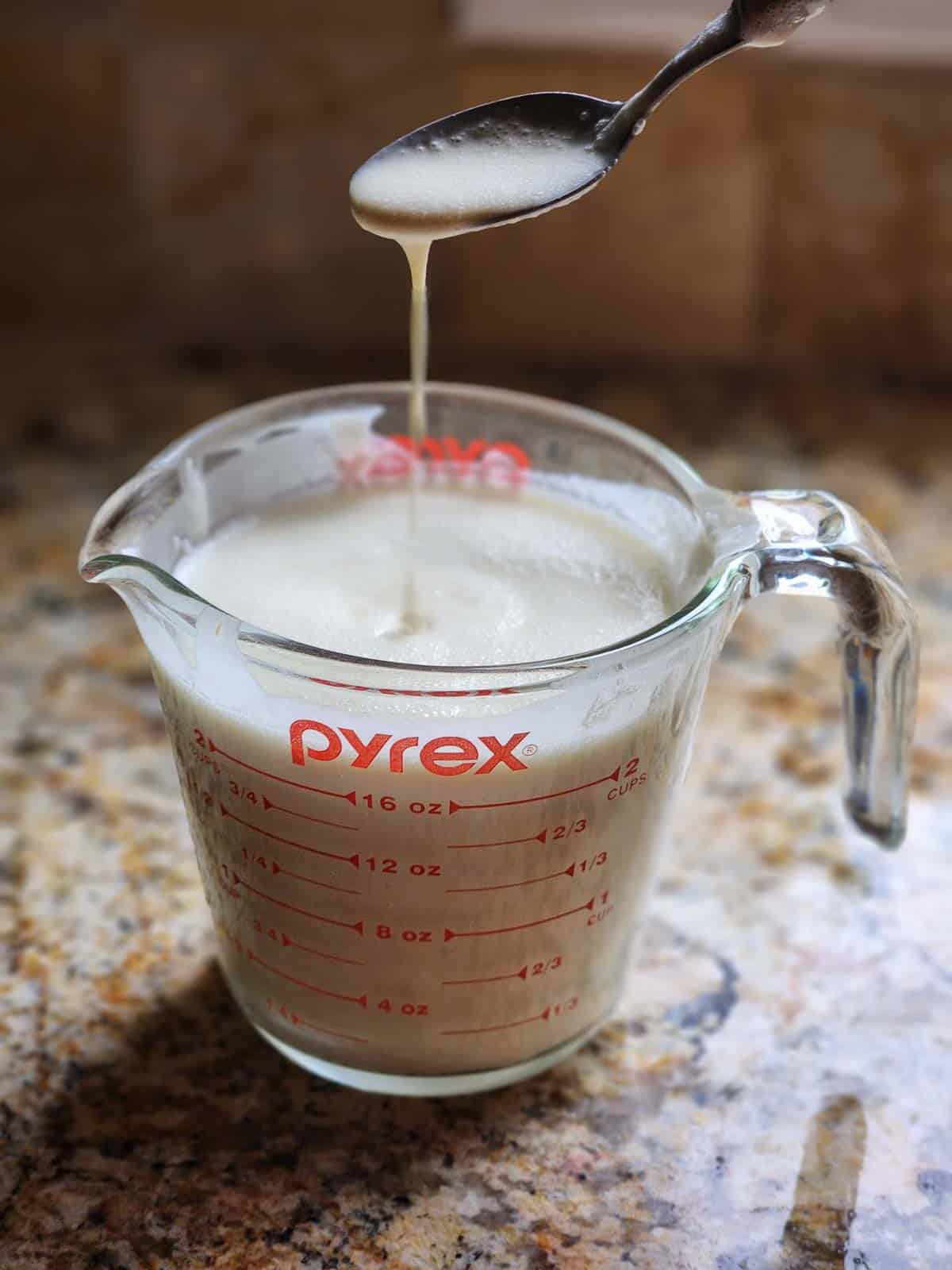 Crepe batter in a clear measuring cup.