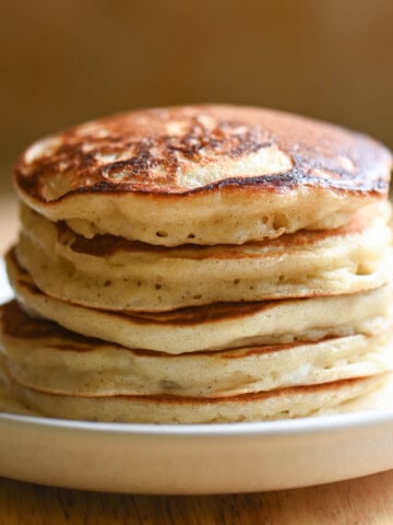 Close up of fluffy pancakes stacked on a plate.