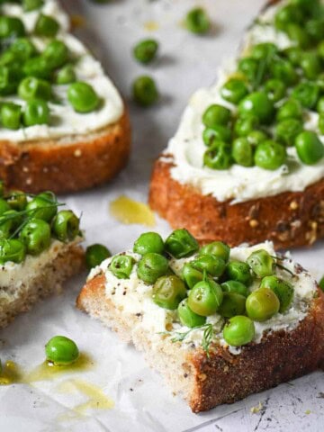 Close up of pea toast cut in half with mascarpone and lemon.