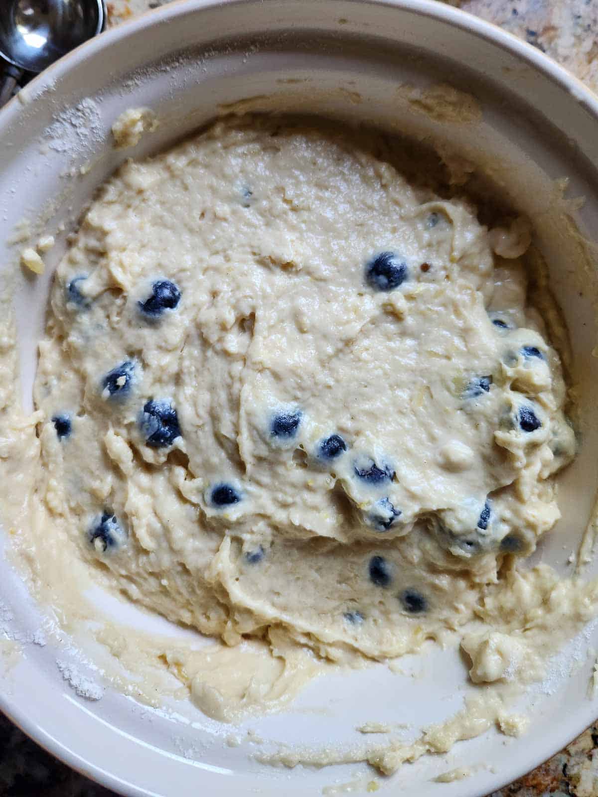 Blueberry muffin batter in a large bowl.