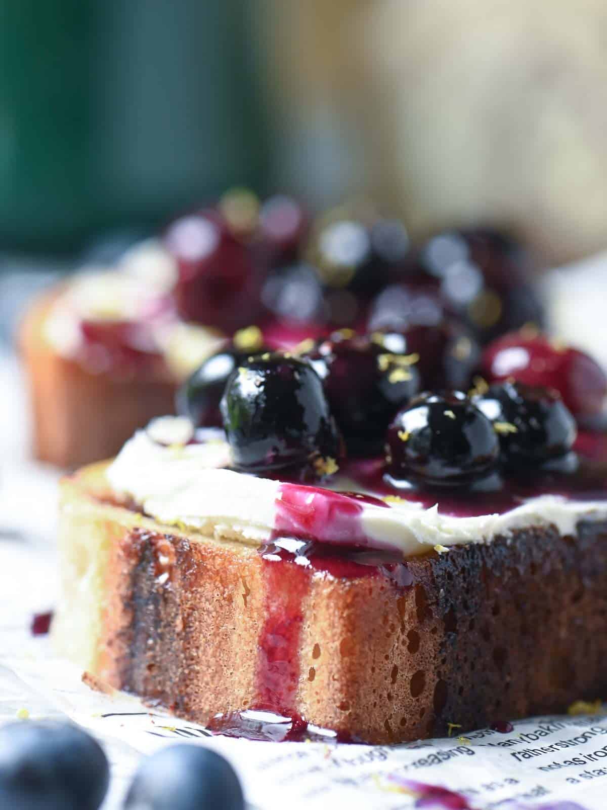 Close-up of blueberries dripping off toast.