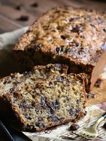Slices of chocolate loaf cake on a metal tray lines with parchment.