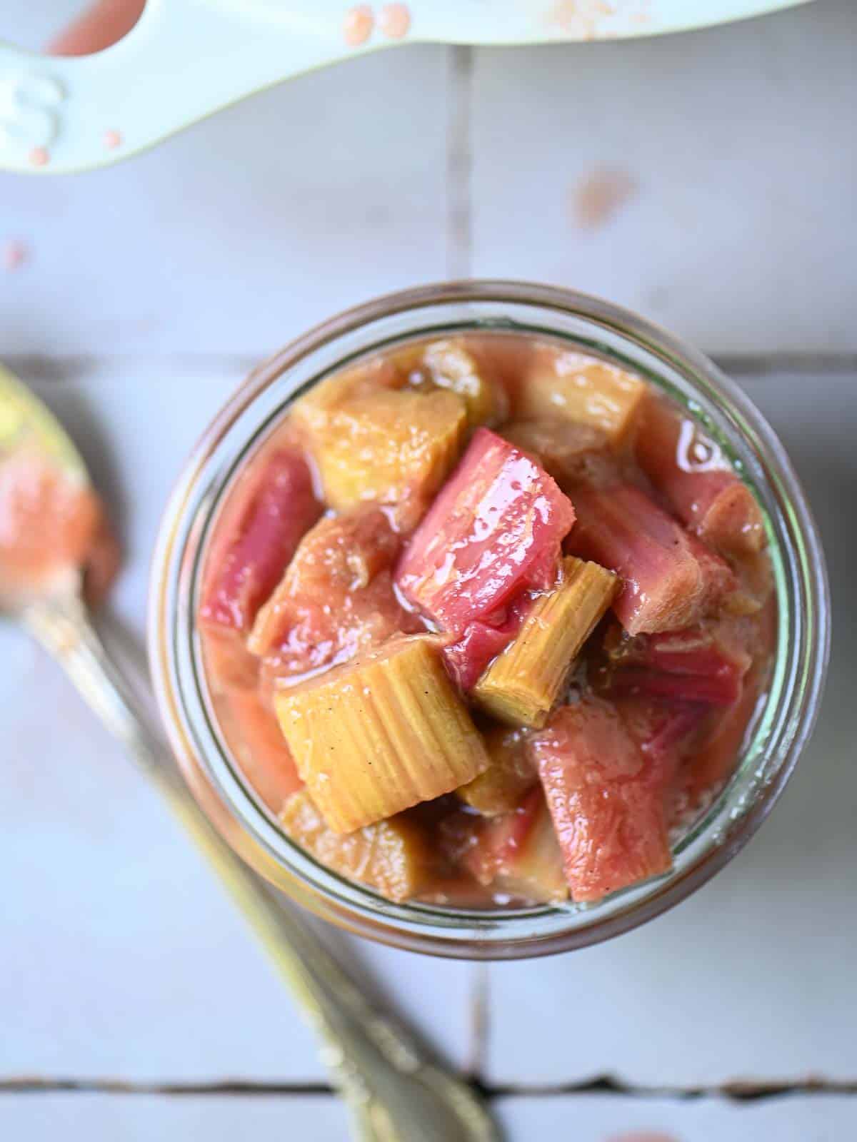 Overhead of rhubarb compote in a glass jar.