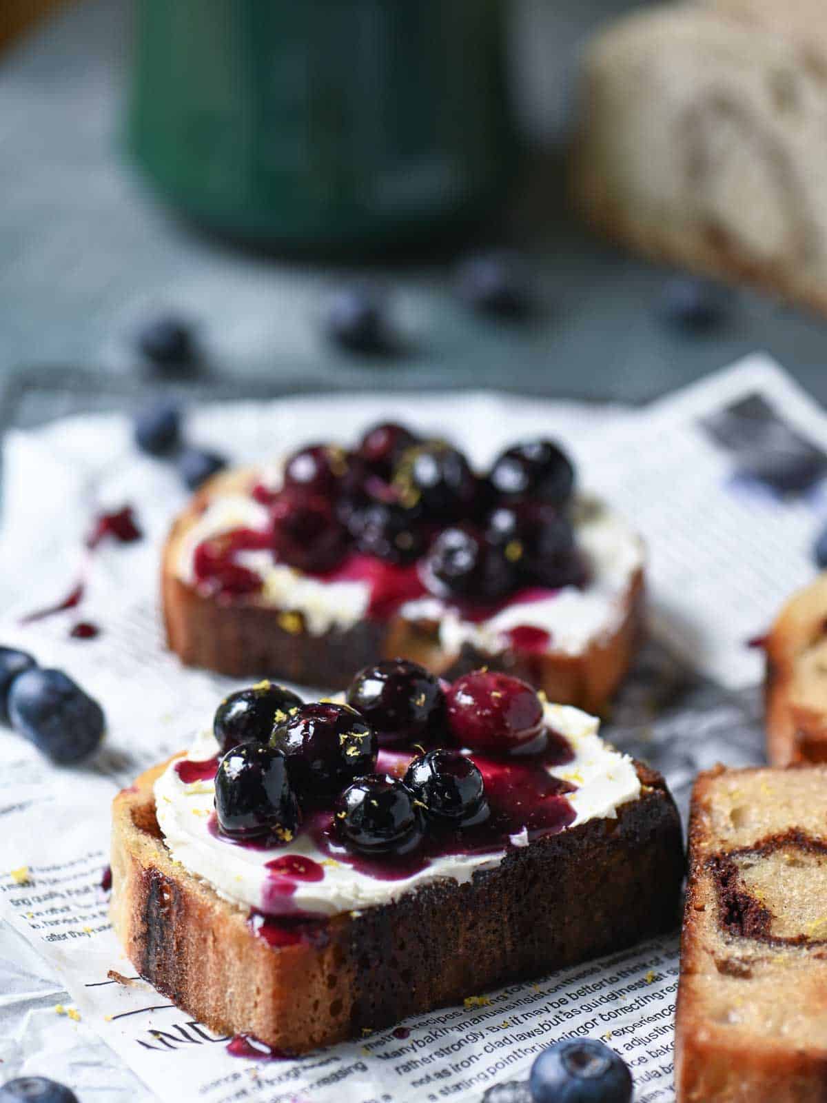 Saucy blueberries on top of cream cheese toast.