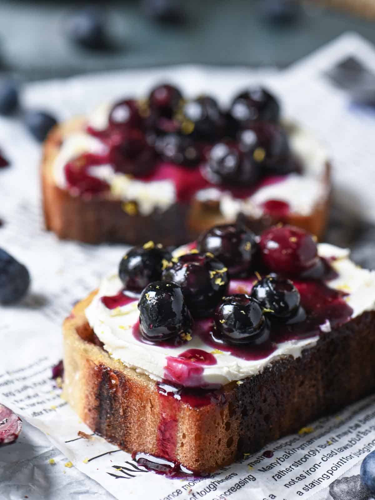Close-up of blueberries on toast on wax paper.