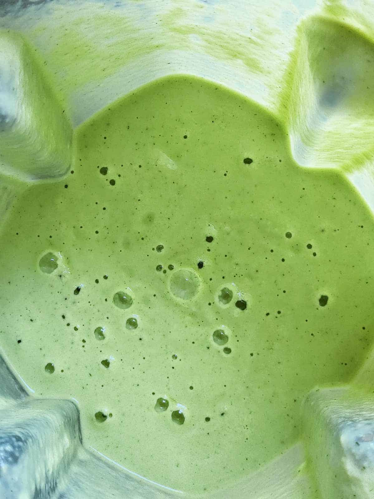 Overhead of cucumber soup blended in a blender.