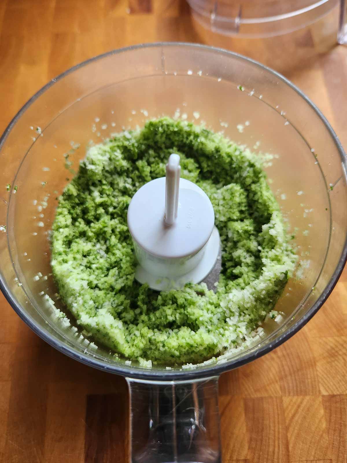 Pulsed basil salt in a food processor.