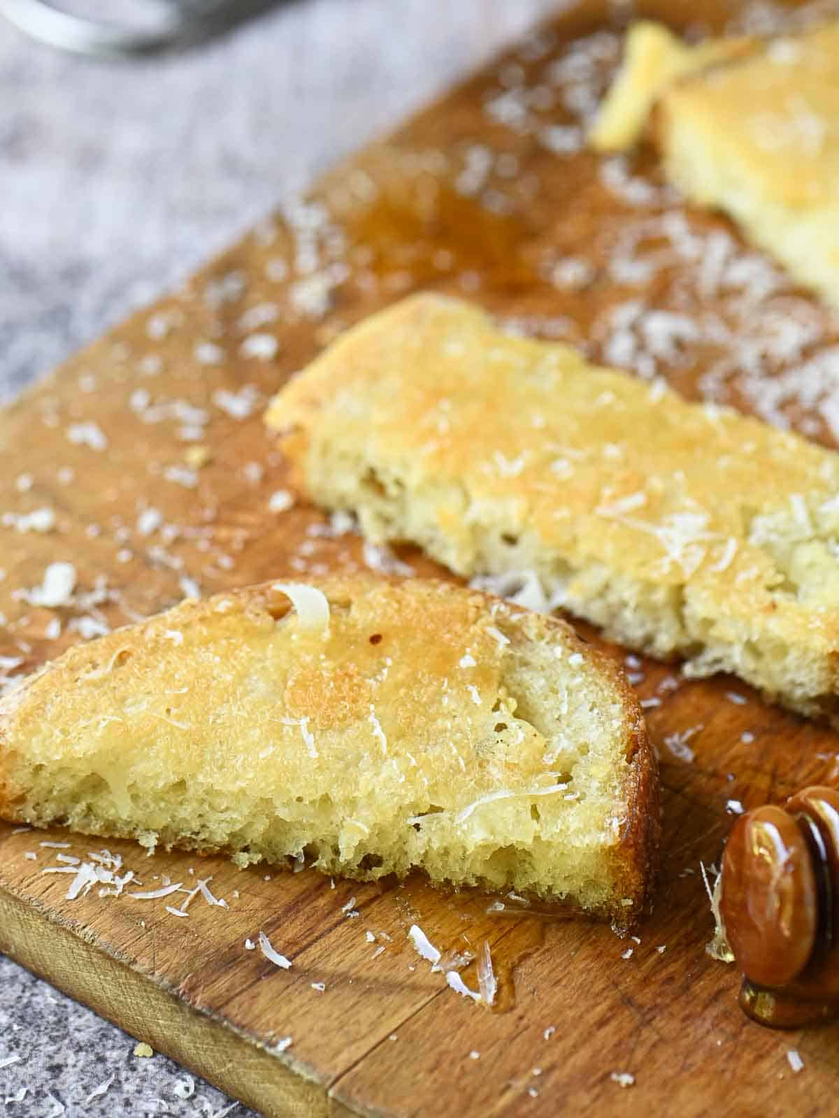 Slices of Parmesan toast on a wooden board.