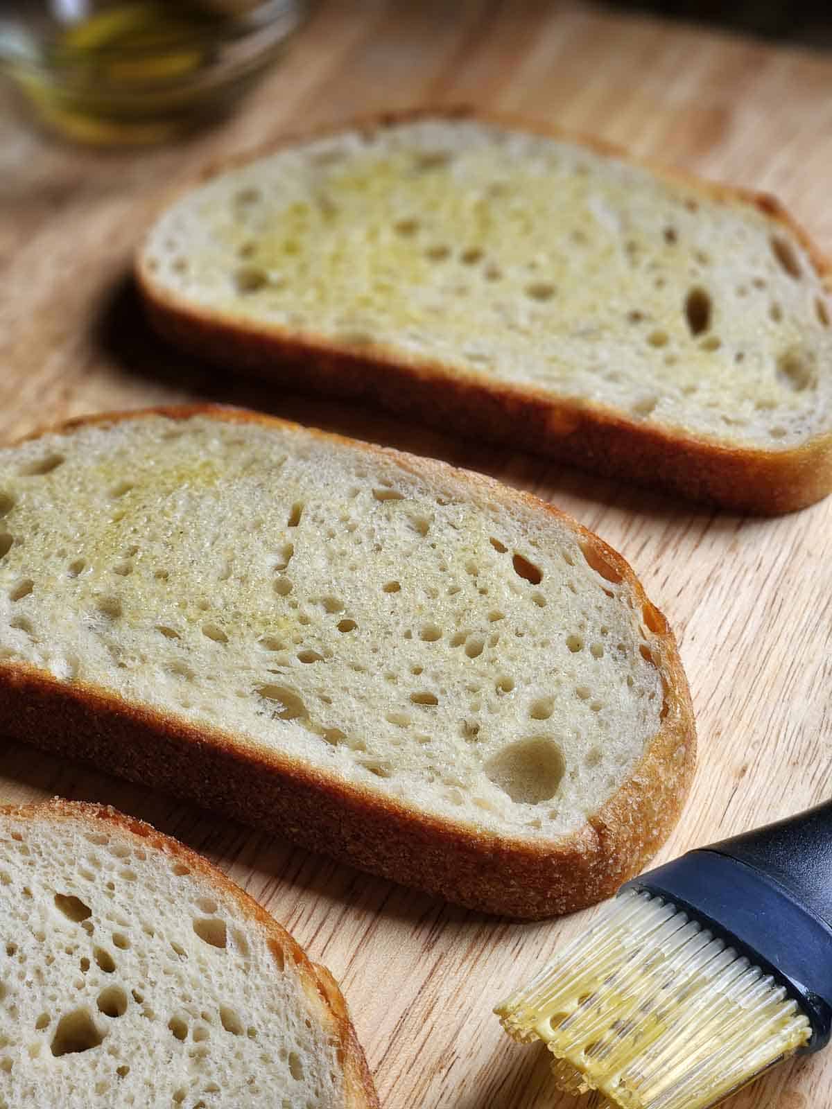 Slices of oiled bread on a cutting board.