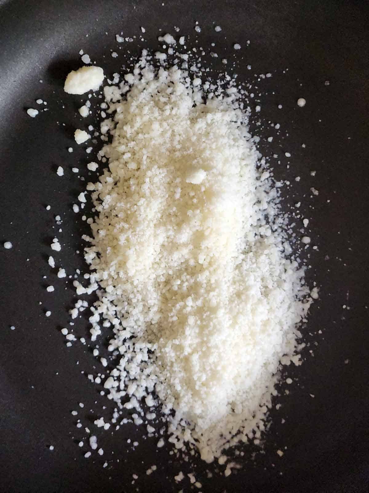Parmesan cheese in a black skillet.