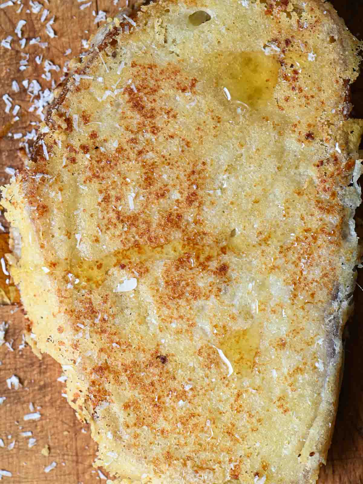 Overhead of Parmesan toast on a wooden board.