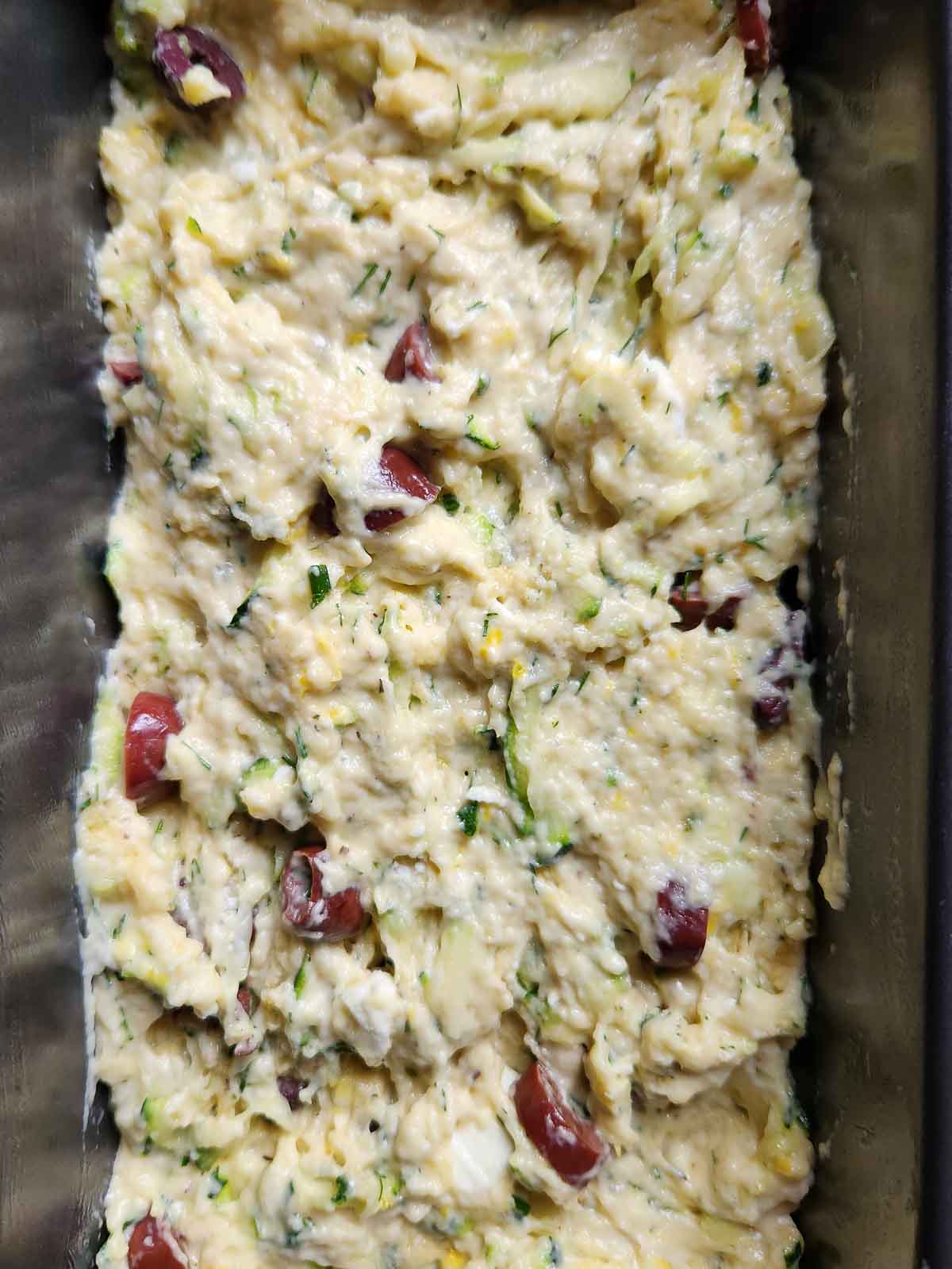Uncooked zucchini batter in a loaf pan.