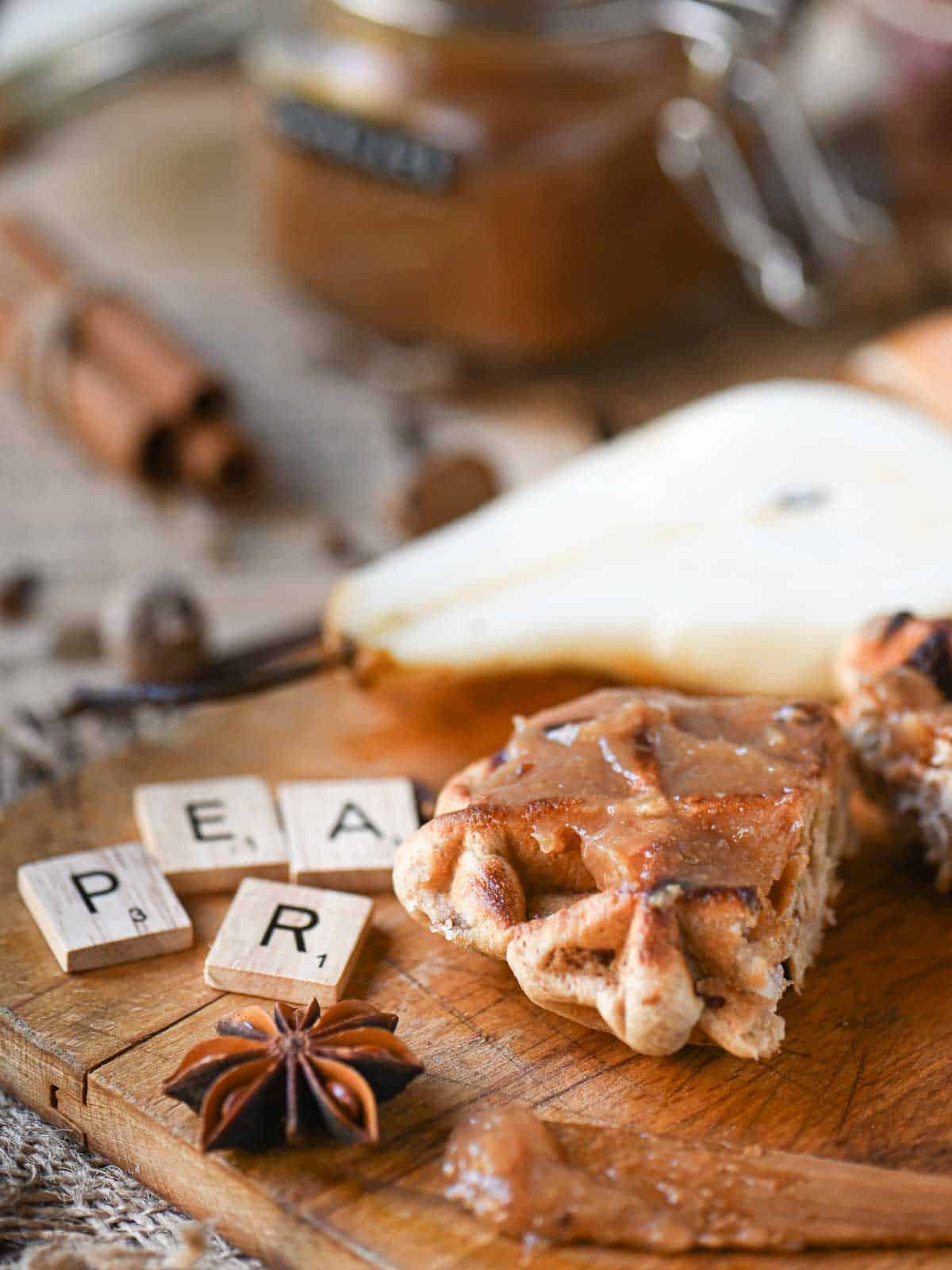 Pear butter spread on a waffle on a cutting board.